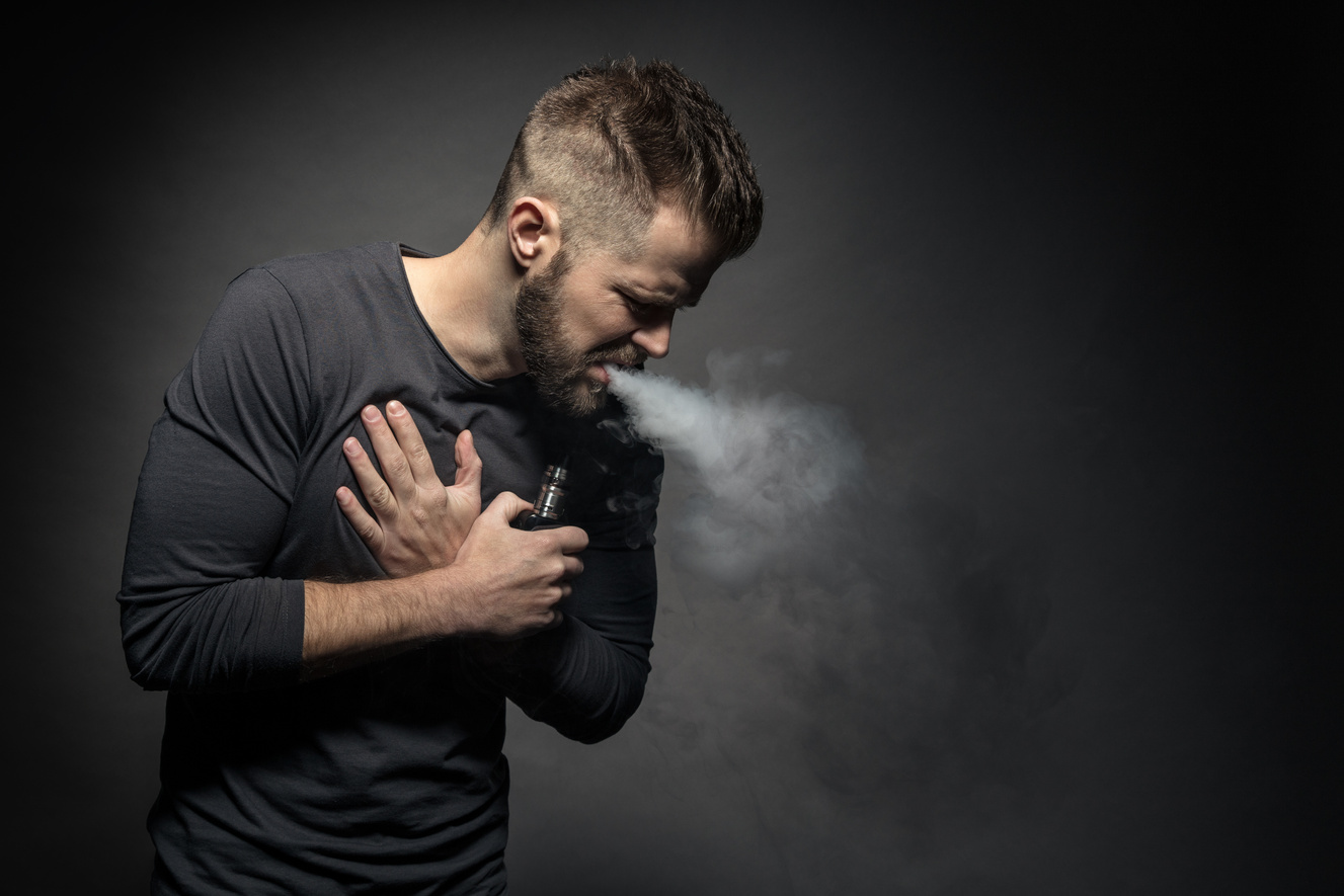 Man with Chest Pain Vaping E-Cigarette Studio Portrait