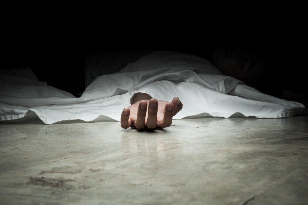 The dead man's body. Focus on hand